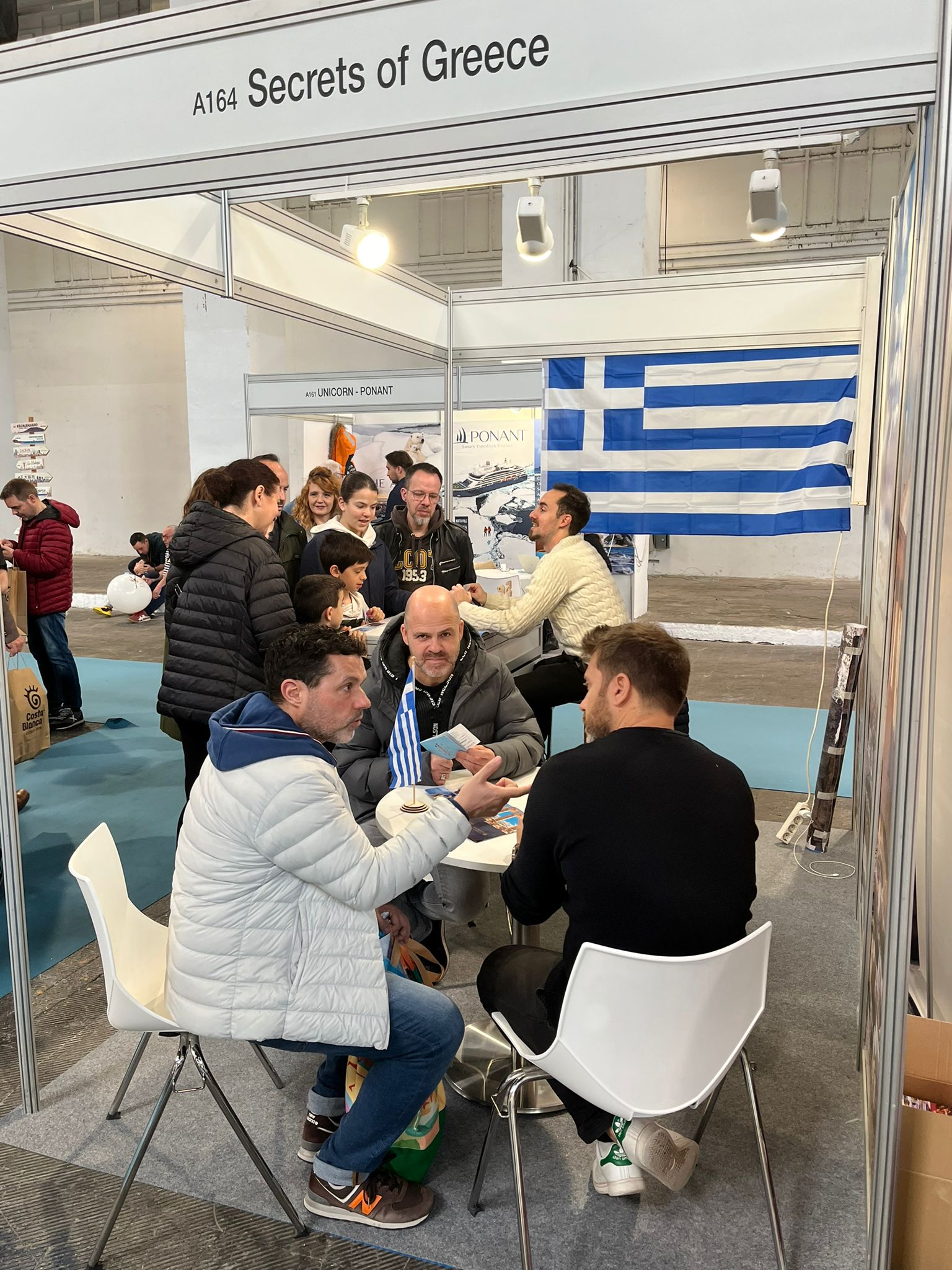 Equipo de Secrets of Greece atendiendo visitantes en un evento turístico